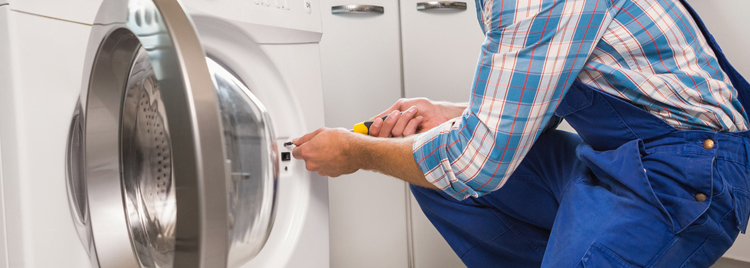 A repair man fixing a washing machine