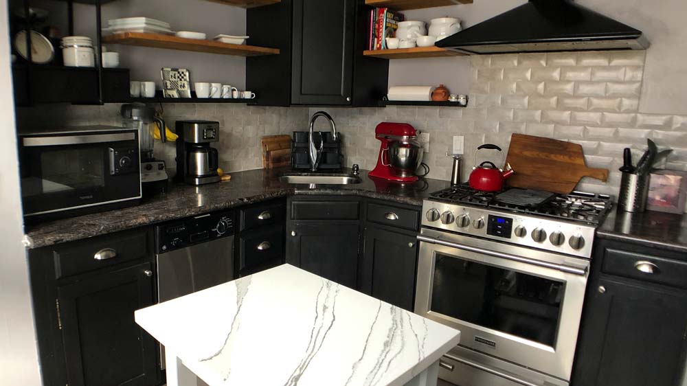 A kitchen with a stainless steel oven & vent hood