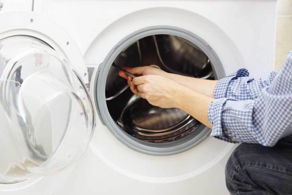 A repair man fixing a dryer