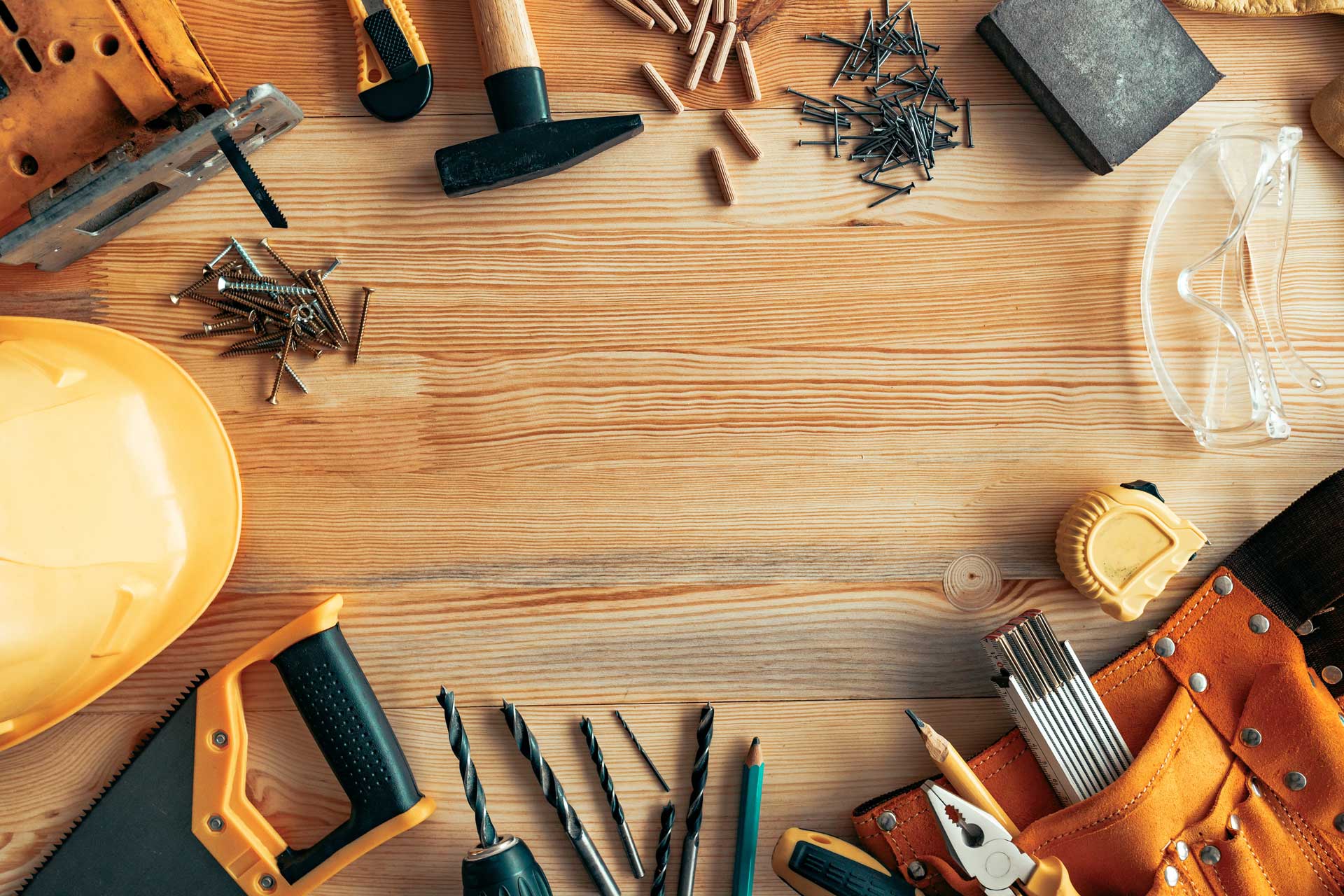 A collection of tools scattered on a wooden workbench