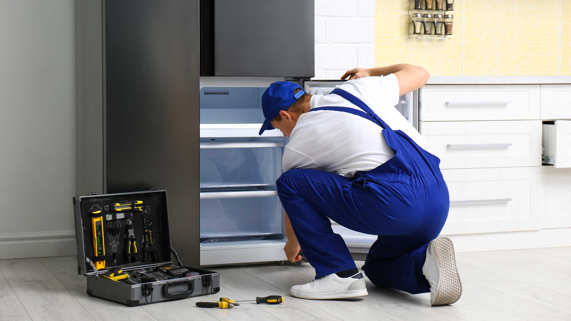 Appliance repair technician fixing a refrigerator